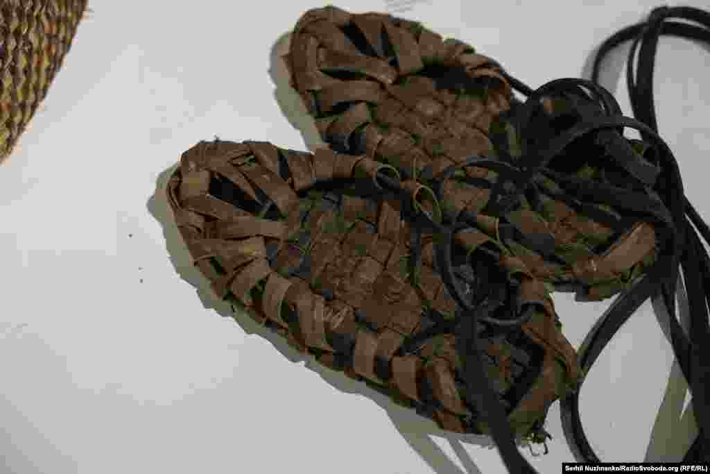 Постоли – традиційне українське мʼяке селянське взуття, поширене до початку XX століття. Його виготовляли з цільного шматка товстої шкіри – свинячої чи коровʼячої.На фото – постоли середини XX століття з села Лубʼянка, що на Київщині