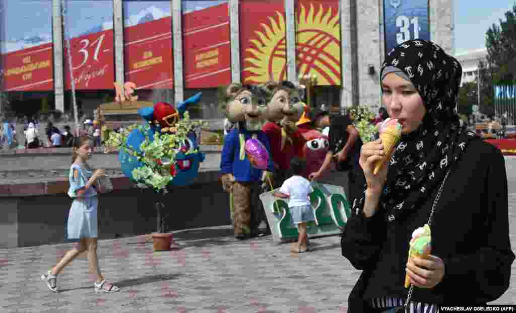 A Kyrgyz woman enjoys an ice cream.