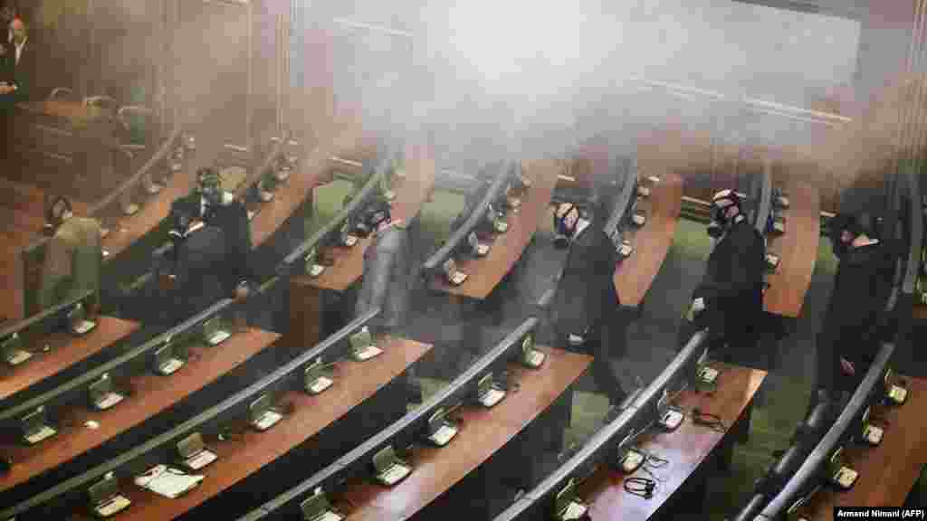 Police officers wearing gas masks inspect Kosovo&#39;s parliament after opposition lawmakers released tear gas in the chamber on Pristina on February 19.&nbsp;(AFP/Armend Nimani)