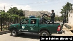 An Afghan police officer keeps watch near the site of a suicide bombing in Kabul on June 4.