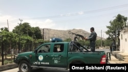 افغانستان: یو افغان پولیس سرباز په کابل کې د عالمانو غونډې سره د شوې چاودنې پس څارنه کوي. د ۲۰۱۸ز کال، ۴ م جون