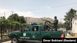 FILE: An Afghan police officer at the site of a bomb attack in Kabul.