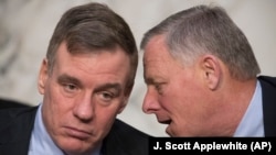 Senate Intelligence Committee Deputy Chairman Mark Warner (left) and Chairman Richard Burr hold a hearing to examine efforts to secure state election systems and to safeguard against foreign meddling earlier this year.