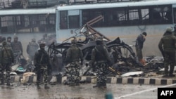 Indian security forces inspect the remains of a vehicle following an bomb attack in Kashmir on February 14.