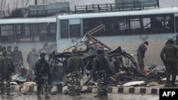 Indian security forces inspect the remains of a vehicle following a bomb attack in Kashmir on February 14.