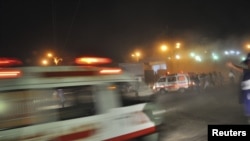 Rescue workers and ambulances are seen at the site of a second bomb blast in Karachi overnight on November 21-22.