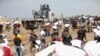 Palestinci nose vreće brašna koje su zgrabili iz kamiona pomoći u blizini izraelskog kontrolnog punkta, dok se stanovnici Gaze suočavaju sa kriznim nivoom gladi, usred sukoba između Izraela i Hamasa, u gradu Gazi, 19. februara 2024. 