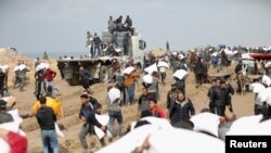 Palestinezët duke marrë thasë me miell nga një kamion i ndihmës në Rripin e Gazës më 19 shkurt 2024. 
