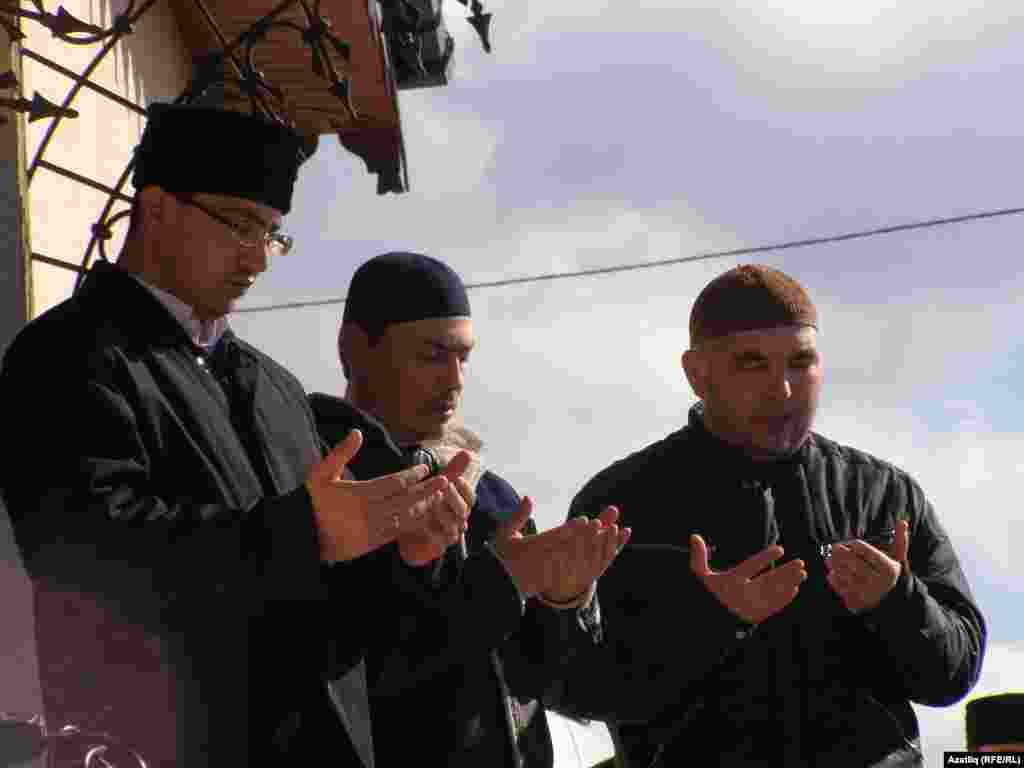 Mourners praying at Reshat Ametov's funeral