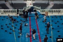 Workers clean the carpet on the inauguration platform in preparation for the January 20 ceremony.