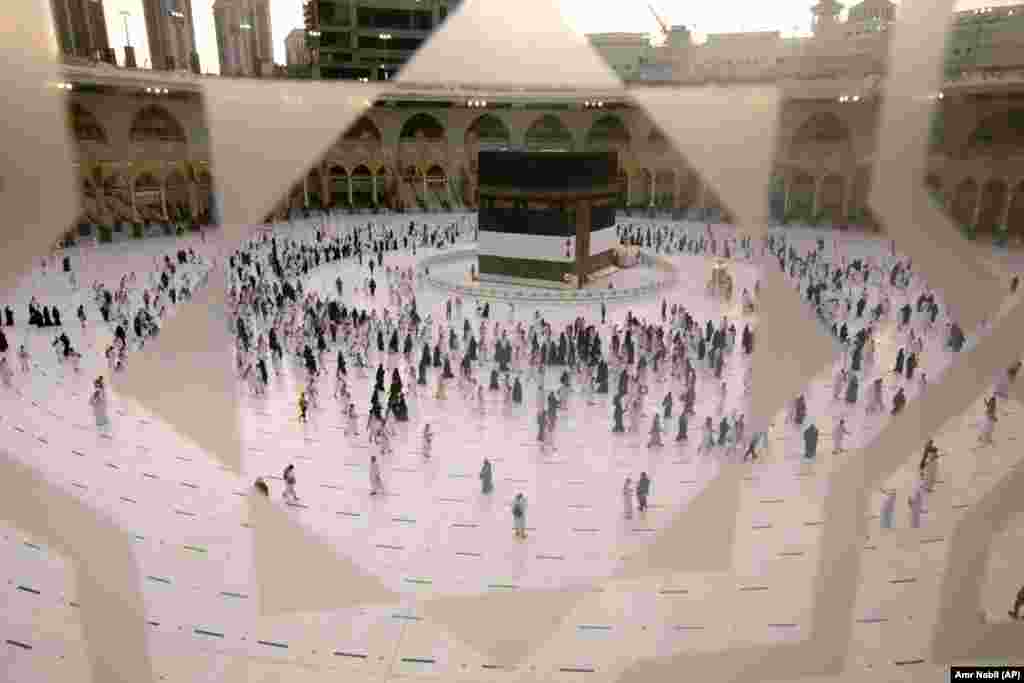 Male grupe hodočasnika, s maskama na licima, posetile su Kabu u subotu - najsvetiju strukturu u islamu i smernice koje muslimani slede da bi se molili - dok zdravstveni radnici nadgledaju njihova kretanja. &nbsp;