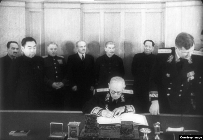 Андрей Вышинский подписывает пакт, своей очереди ждёт Чжоу Эньлай (второй слева). На заднем плане – Сталин и Мао