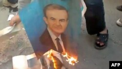Demonstranti pale fotografiju Hafeza al-Assada, Damask, mart 2012.