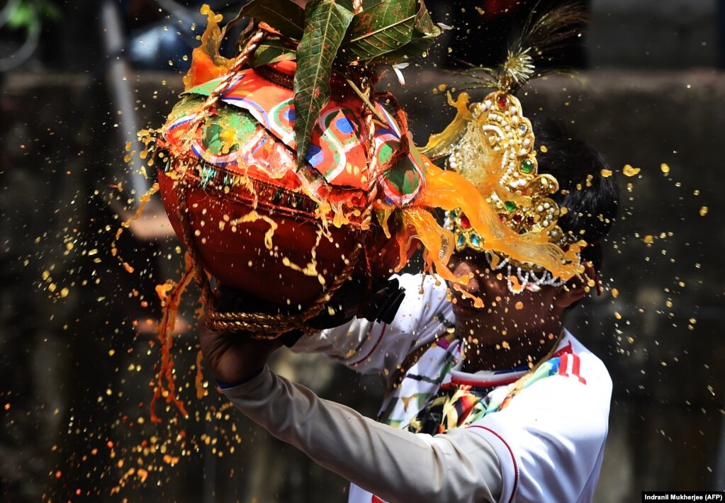 An Indian Hindu devotee breaks a dahi-handi -- or curd pot -- during celebrations for the Janmashtami festival, which marks the birth of the Hindu god Lord Krishna, in Mumbai. (AFP/Indranil Mukherjee)