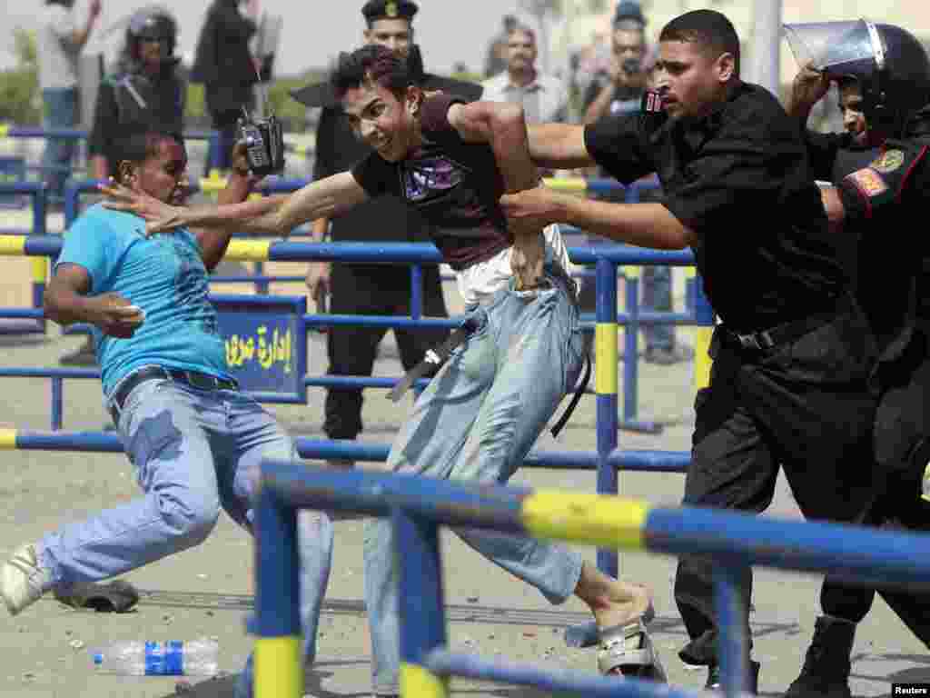 An anti-Mubarak demonstrator is detained by police after clashes with pro-Mubarak demonstrators and police outside former President Hosni Murbarak's trial in Cairo on September 5. (Photo by Amr Abdallah Dalsh for Reuters)