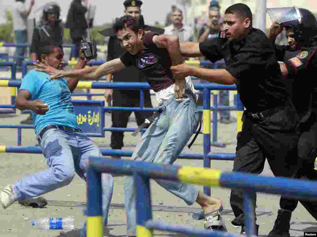 An anti-Mubarak demonstrator is detained by police after clashes with pro-Mubarak demonstrators and police outside former President Hosni Murbarak&#39;s trial in Cairo on September 5. (Photo by Amr Abdallah Dalsh for Reuters)