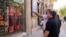 People look at currency exchange rates displayed on an electronic board on the window of a shop in in Ferdowsi Square in the Iranian capital Tehran on September 28.