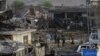 Pakistani security officials investigate the site of a bombing in Lahore on August 7.