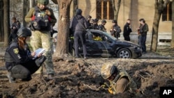 Military experts examine the site of a Russian bombing that killed several people in Kharkiv on April 6.
