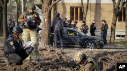 Ekspertët ushtarakë duke e ekzaminuar zonën ku një bombë ruse i vrau disa njerëz në Harkiv, Ukrainë, 6 prill 2024.
