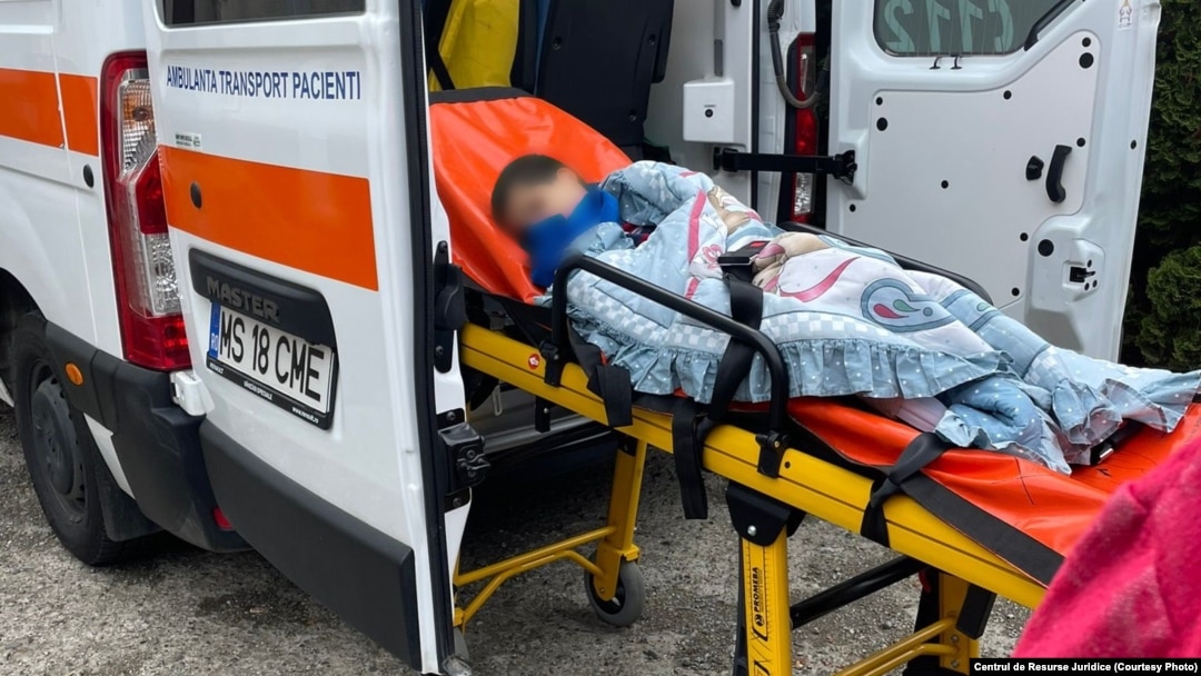 Un copil de la unul dintre centrele pentru copiii cu dizabilități de la Târgu Mureș este urcat într-o ambulanță.