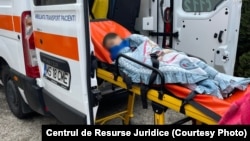 Un copil de la unul dintre centrele pentru copiii cu dizabilități de la Târgu Mureș este urcat într-o ambulanță.