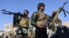 Afghan security personnel stand guard outside a mosque during Eid al-Adha prayers in Herat on July 20.