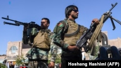 Afghan security personnel stand guard outside a mosque during Eid al-Adha prayers in Herat on July 20.