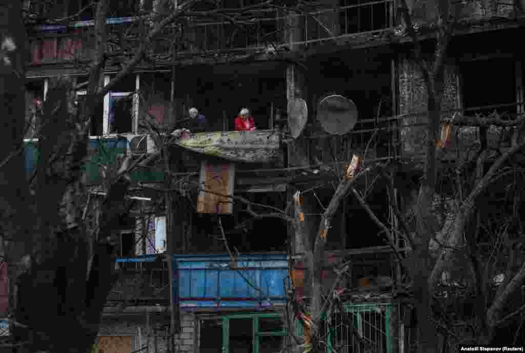 Banorët qëndrojnë në ballkonin e banesës së tyre që gjendet në një ndërtesë të dëmtuar nga dronët rusë në Kramatorsk në rajonin e Donjeckut më 2 dhjetor 2025.