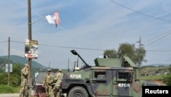 FILE PHOTO: Members of the KFOR peacekeeping force patrol the area near the border crossing between Kosovo and Serbia in Jarinje