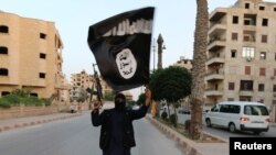 په منځني ختیځ کې د اسلامي دولت ډلې یو غړی د خبل بیرغ د لېږدولو پر مهال - ارشیف 