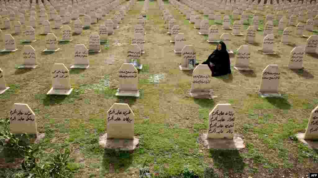 A Kurdish woman visits the grave of her relatives who were killed in a gas attack by former Iraqi leader Saddam Hussein in 1988 on the 24th anniversary of the attack at the memorial site for the victims in the Kurdish town of Halabja. (AFP/Safin Hamed)
