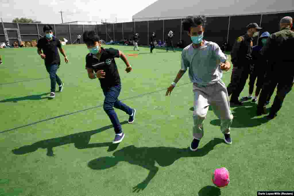Gyerek és fiatalkorú menekültek fociznak az átmeneti menedékhelyen.