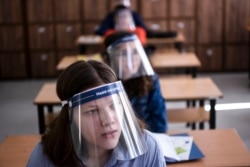 Студенты из Косова, сдающие экзамен в пластиковых щитках. Июнь 2020 года