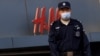Охранник у магазина H&M в Пекине. 9 апреля 2021 года.