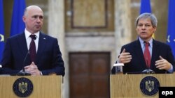 Moldovan Prime Minister Pavel Filip (left) looks on while Romanian counterpart Dacian Ciolos addresses journalists at the end of their official meeting in Bucharest on January 26.