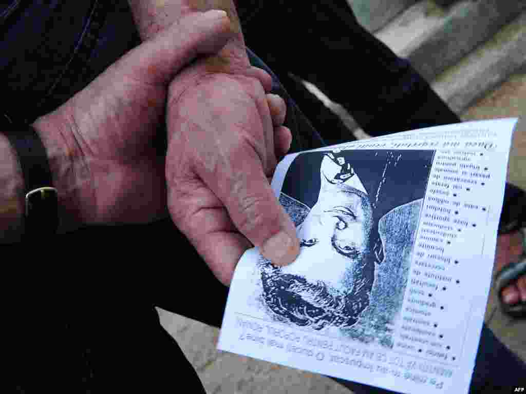 A man holds a portrait of late Romanian dictator Nicolae Ceausescu at Ghencea cemetery in Bucharest on July 21 after Nicolae Ceausescu and his wife Elena's remains were exhumed for DNA tests, a move meant to dispel one of the mysteries surrounding the communist regime's 1989 fall. Photo by Daniel Mihailescu for AFP