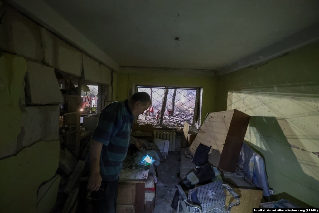 Një banor vlerëson dëmet në banesën e tij në Kiev.