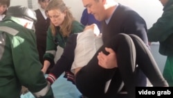 Медики переносят отравившуюся девочку в Березовке. Западно-Казахстанская область, 21 января 2015 года. 