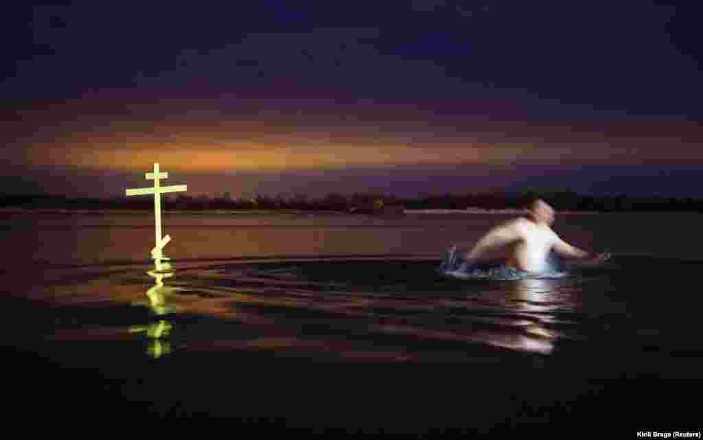 A man walks next to a cross after taking a dip in the shallow water of the Volga River during celebrations of the Orthodox Christian feast of Epiphany in Volgograd, Russia, on January 19. (Reuters/Kirill Braga)