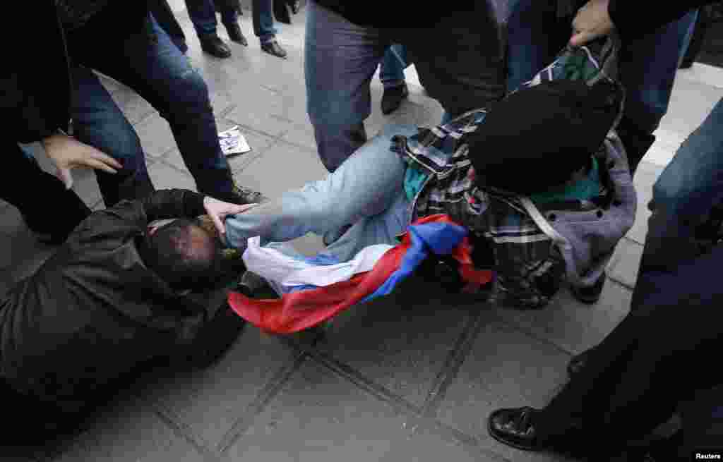 An anti-Russian activist (right) takes away a Russian flag from a pro-Russian activist during a rally in Tbilisi on March 27. (Reuters/David Mdzinarishvili)