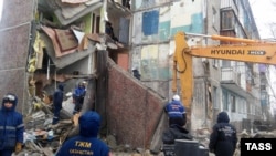 Rescuers search for survivors amid the rubble of a collapsed residential building in the central town of Shakhan on January 2.