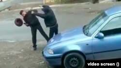 Милицияны уруп жаткан тасмадан алынган сүрөт.