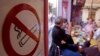 Customers smoke cigarettes next to a no smoking sticker in a bar in Marseille, December 28, 2007.