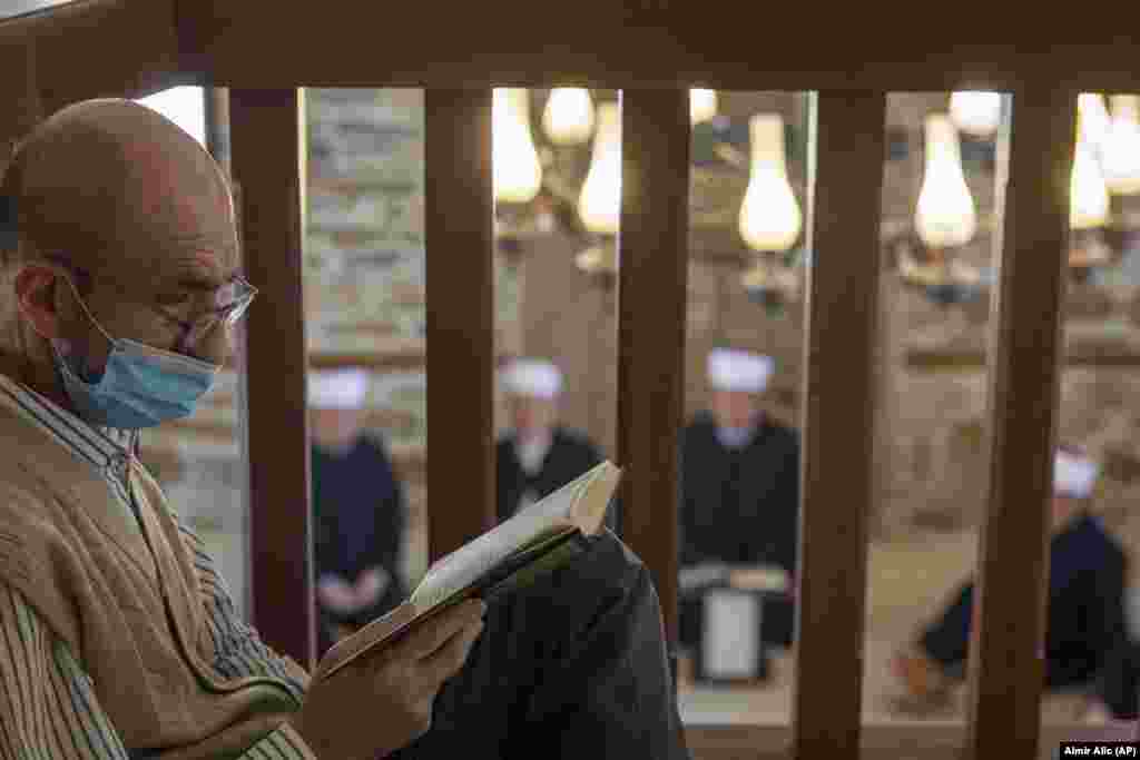 A man reads the Koran as imams attend the Ramadan prayer in a mosque without worshippers in Zenica, central Bosnia, on April 23.