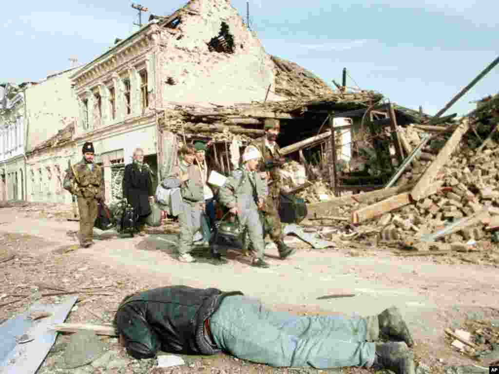 Croatia -- Serb troops and civilians pass a body in Vukovar, 18Nov1991 - Srpske trupe i civili prolaze pored tela žrtve ubijene u Vukovaru, novembar 1991.