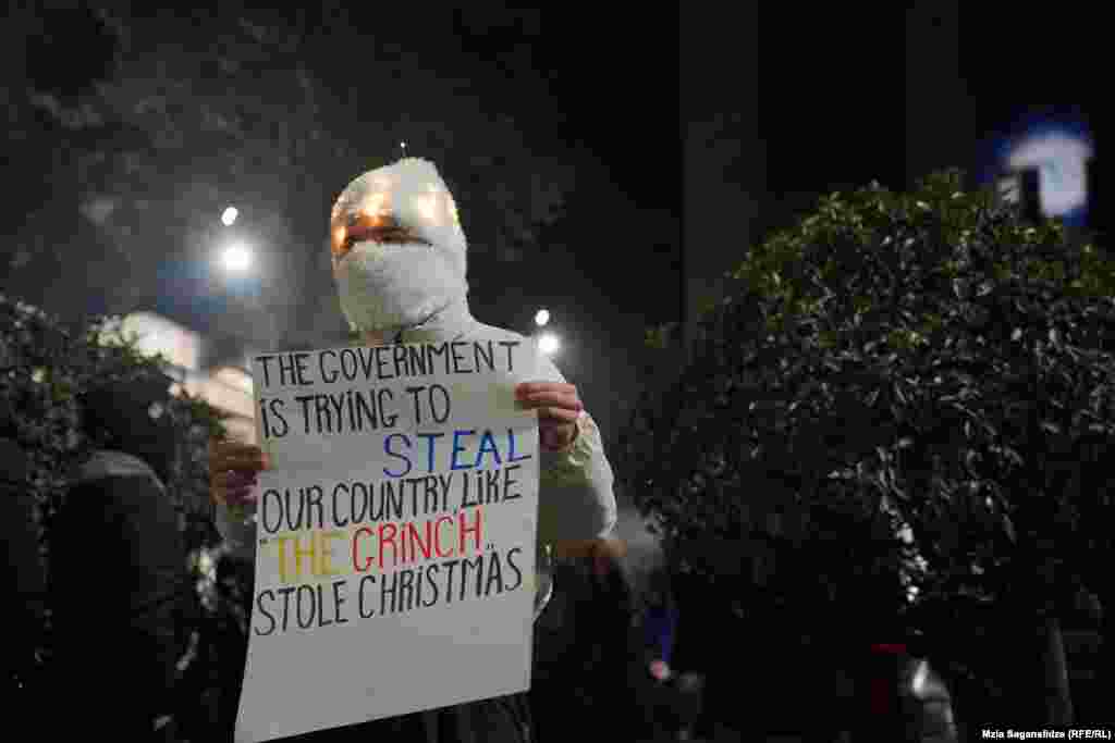 Një demonstrues ka shkruar mendimin e tij në një pankartë gjatë protestave kundër zgjedhjeve parlamentare të tetorit, Tbilisi, 1 dhjetor 2024.