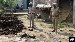 Police officers inspect parts of a projectile attached to drone intercepted by the Indian Army in Wadala Bhattewad village near Amritsar, India, on May 10