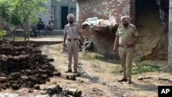 Oficerët e policisë inspektojnë pjesë të një predhe të bashkangjitur në një dron në fshatin Wadala Bhittewad pranë Amritsar, Indi, më 10 maj.