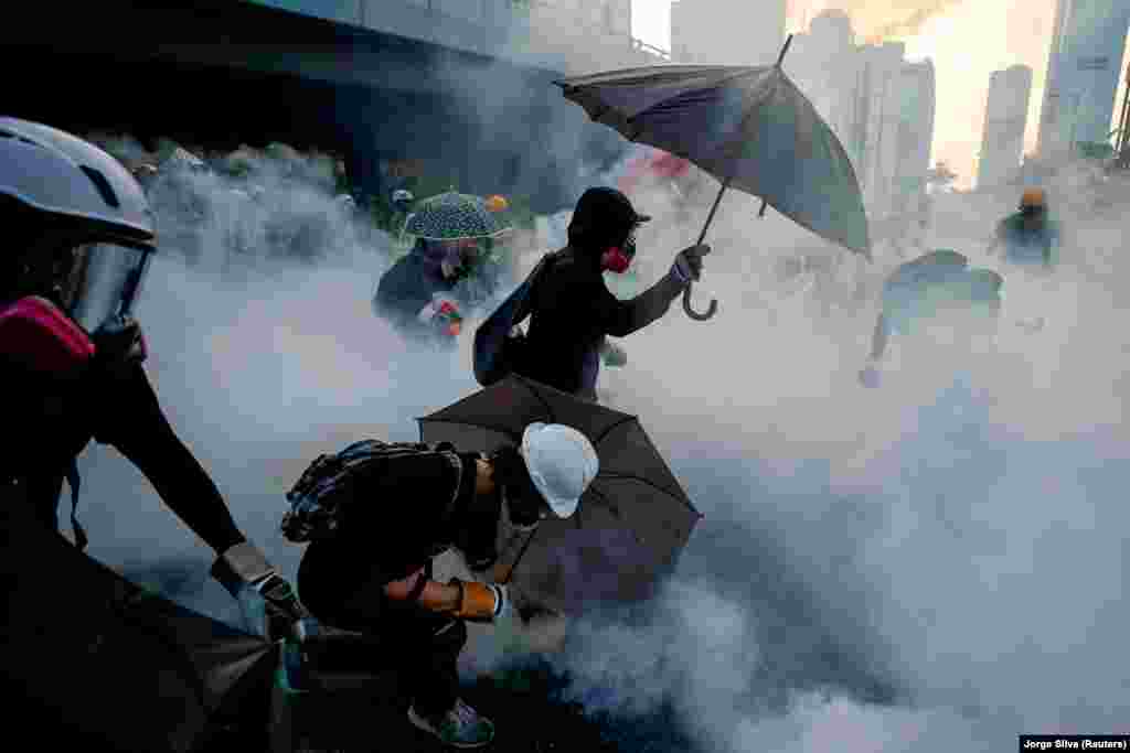 Anti-government protesters protect themselves with umbrellas from tear gas during a demonstration near government buildings in Hong Kong on September 15, 2019. (Reuters/Jorge Silva)